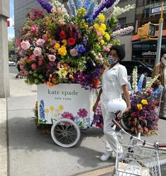 a person pushing a cart with flowers on it