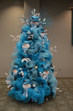 a blue christmas tree with snowmen and birds on it