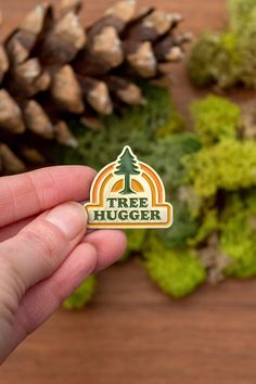 "Wear your love for trees on your sleeve, with this tree-inspired enamel pin. Great for adding a little retro, nature flair to your hat, backpack, or lapel. Professionally designed by me and ethically-sourced for production, so you can feel good about what you're purchasing. ✿ DETAILS ✿ ‣ 1.25\" ‣ Soft enamel ‣ Antique gold finish on 60%-70% recycled metal ‣ Rubber backing ‣ Ethically sourced ‣ Designed by me. Produced with the help of a production partner. ✿ WHOLESALE ✿ To order wholesale, plea Olive Tree Pin, Cheap Vintage Enamel Pins, Retro Nature, Velcro Patches, Soft Enamel Pins, Tree Hugger, Forest Design, Hat Pin, Soft Enamel