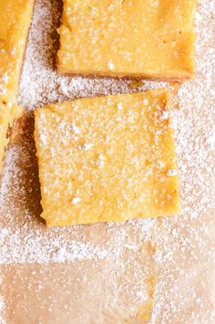 three pieces of cake sitting on top of a cutting board covered in powdered sugar