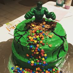 a green cake decorated with sprinkles and a large hulk figure on top