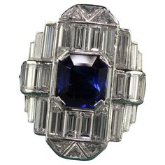 Beautiful Vintage Art Deco Platinum Baguette Diamond and Sapphire Cocktail Ring - GIA. This gorgeous Art Deco cocktail ring is crafted in platinum. The center holds a natural royal blue sapphire that has a GIA report and has white baguette cut diamonds and trillion cut diamonds set all of the top. The ring looks like a sheet of mirror and extremely sparkly! The ring is in great condition and has a serial number inside the shank. This is a remarkable ring and very rare to come by! Item #R1733 Metal: Platinum Weight: 11 Grams Size: 5 3/4 Diamonds: Approximately 4.5 cts Color: H Clarity: VS2 Sapphire: 1.87 ct - GIA # 1182009392 Measurements: Top of the ring measures 21.9 mm wide and band measures 1.75 mm wide. Measurements off the finger: 7.44 mm high Layaway: For your convenience, we will be Antique Rings 1stdibs, Wide Band Diamond And Sapphire Rings, Vintage Jewelry Rings 1stdibs, Art Deco Cocktail, Deco Rings, Sapphire Cocktail Ring, Jewels Rings, Art Deco Diamond, Gorgeous Art