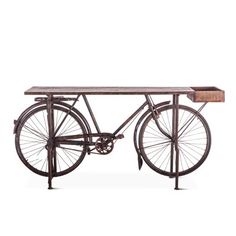 an old fashioned bicycle sitting on top of a wooden table