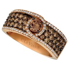 a fancy ring with brown and white diamonds on the sides, set in 18k gold