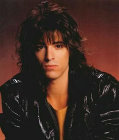 a man with long hair wearing a leather jacket