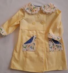 This gorgeous coat is made from vintage yellow damask and comes in a size 2. It is the matching coat to a delightful vintage dress (https://www.etsy.com/your/shops/LittleLarkClothing/tools/listings/791702327) This coat has vintage cotton lace trimming and pockets on the front made from the fabric of the matching dress. It is the most adorable matching outfit, and one-of-a-kind in a size 2. The coat is inspired by Princess Charlotte's wardrobe and any little girl who is lucky enough to wear it wi Yellow Long-sleeved Dress With Pockets, Long Sleeve Yellow Dress With Pockets, Yellow Long Sleeve Dress With Pockets, Spring Cotton Costume Dress, Spring Costume Outerwear With Long Sleeves, Handmade Long Sleeve Spring Dresses, Handmade Long Sleeve Dresses For Spring, Cute Spring Outerwear With Buttons, Vintage Spring Outerwear With Covered Buttons