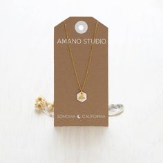 This necklace features a luminous 12mm Mother of Pearl hexagon as a honeycomb with a tiny bee. It hangs on an 18" vintage style beaded chain. The chain is 14k gold plated brass and coated to resist tarnish and create a hypoallergenic surface. Expertly crafted to last, this necklace showcases a radiant 12mm Mother of Pearl hexagon in the shape of a honeycomb with a delicate bee. The 18" chain boasts a vintage look and beaded design, constructed from 14k gold plated brass for a lustrous finish and Hexagon Faceted Necklace For Gift, Hexagon Faceted Necklace For Gifts, Faceted Hexagon Necklace For Gift, Faceted Hexagon Necklace For Gifts, Gold Hexagon Faceted Necklace, Minimalist Gold Hexagon Necklace, Sonoma California, Bee Necklace, Studio Logo