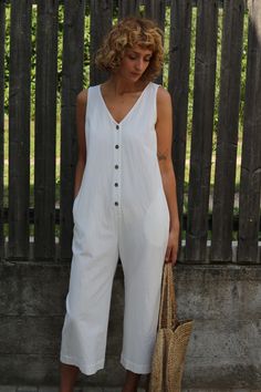 Summer V-neck Jumpsuits And Rompers With Buttons, Casual V-neck Jumpsuit With Button Closure, Casual V-neck Jumpsuits And Rompers With Button Closure, White Cotton Jumpsuits And Rompers For Beach, White Cotton Beach Jumpsuits And Rompers, Casual Cotton Sleeveless Jumpsuits And Rompers, White Cotton V-neck Jumpsuit, Casual Sleeveless Cotton Jumpsuits And Rompers, White Cotton V-neck Jumpsuits And Rompers