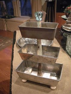 three tiered metal trays on top of each other in the middle of a living room