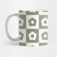 a green and white coffee mug with flowers on it