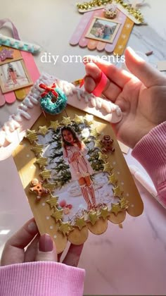 a person holding up a card with a picture on it and some decorations around the edges