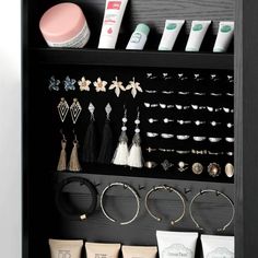 a black shelf filled with lots of earrings and other jewelry on it's sides