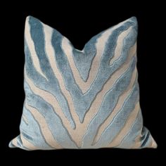 a blue and white zebra print pillow on a black background