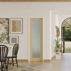 a dining room table and chairs in front of an open doorway with pictures on the wall