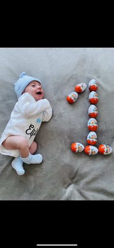 a baby laying on top of a bed next to the letters e and f written in candy