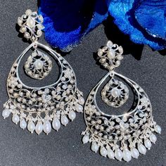 Indulge in the allure of heritage and sophistication with our sterling silver chandbali earrings, featuring delicate floral motifs and exquisite pearls. Crafted to perfection, these earrings seamlessly blend tradition with modern elegance, adding a touch of opulence to any ensemble. Elevate your style with timeless grace and charm, as each pair whispers tales of luxury and refinement. Elegant Chandbali Pearl Earrings For Festive Occasions, Elegant Chandbali Pearl Earrings For Party, Elegant White Chandbali Earrings, Elegant Chandbali Earrings, Festive Elegant Design Chandelier Earrings, Ornate Sterling Silver Earrings With Elegant Design, Elegant Pearl Drop Earrings For Festive Occasions, Luxury Drop Chandelier Earrings With Intricate Design, White Chandbali Earrings With Elegant Design