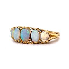 This antique Victorian era ring boasts an antique feel that will transport you to a time of glamour and luxury. Crafted from 18 karat yellow gold, this ring features beautiful cabochon opals as the primary stones and are set across the entirety of the band. The opals are complemented by eight diamonds, adding a hint of sparkle. Its timeless beauty and exceptional quality make it the perfect addition to any jewelry collection. Whether you're looking for a statement piece for a special occasion or Luxury Victorian Opal Ring, Luxury Cabochon Opal Ring, Heirloom Yellow Gold Oval Cabochon Opal Ring, Vintage Opal Ring With Oval Cabochon, Vintage Opal Rings In Yellow Gold, Victorian Style Gold Opal Ring With Multi-stone, Vintage Multi-stone 14k Gold Opal Ring, Vintage 14k Gold Multi-stone Opal Ring, Vintage Multi-stone Yellow Gold Opal Ring