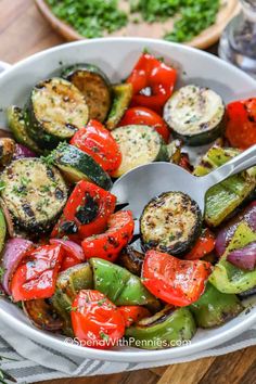 a white bowl filled with grilled vegetables on top of a wooden table