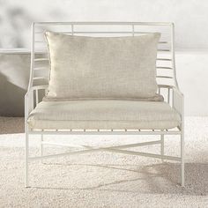 a white chair sitting on top of a carpeted floor next to a planter