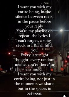 a poem written on the side of a street at night with buildings in the background