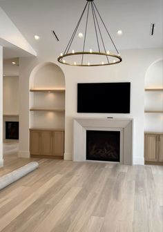 an empty living room with wood floors and white walls