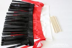 there are many pieces of black and red paper on the table with chopsticks