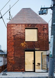 a small brick building sitting on the side of a street next to a traffic light