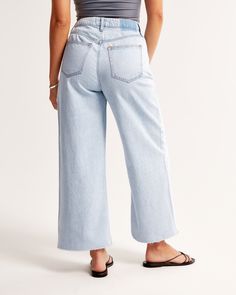 Our Curve Love high rise cropped wide leg jeans in a light wash with a raw-cut hem. This fit features a 10.5” high rise, is relaxed at the waist and hips, and eases into a wide, full-length leg shape with a cropped length. Our Curve Love styles add an additional 2” at the hip and thigh to allow room for your curves and eliminate waist gap. This jean is made from our super light drapey denim fabric, which features a super soft lightweight rigid denim. Summer Light Wash Relaxed Fit Cropped Jeans, Cropped Medium Wash Bottoms With Frayed Hem, Light Wash Cropped Denim Bottoms, Light Wash Cropped Jeans With Five Pockets, Spring Cropped Jeans With Frayed Hem, Spring Cropped Light Wash Pants, Spring Light Wash Pants With Frayed Hem, Spring Light Wash Cropped Pants, Light Wash Cropped Cotton Flare Jeans