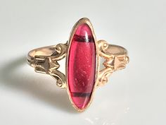 Very pretty antique ruby navette ring from the Victorian era in 10K yellow gold. This lovely ring features a marquise-cut cabochon ruby in a classic late Victorian oval bezel mount. The ruby is a simulated ruby, typical of the era, and measures 16.4x6mm and appears to be original to the ring with no chips or cracks and only very minimal age related wear. Beautiful. classic late Victorian-Art Nouveau detail to the sides. The shank is a beautiful handmade double shank and is solid all around. Ring Navette Ring, Antique Ruby Ring, Aquamarine Ring Vintage, Cabochon Ruby, Sapphire Solitaire Ring, Princess Ring, Sapphire Solitaire, Cabochon Ring, Victorian Art