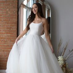 a woman in a white wedding dress posing for the camera