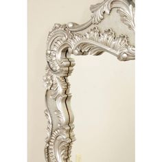 an ornate silver framed mirror against a white wall