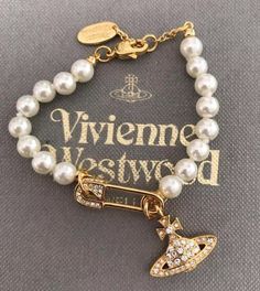 Vivienne Westwood Gold Pearl Safety Pin Saturn Bracelet 6 / 6.5 / 7 Inches due to included tail adjustment, also comes with free pouch, papers, and cleaning cloth. Vivienne Westwood Pearl Bracelet, Vivienne Westwood Safety Pin, Gold Vivienne Westwood, Saturn Bracelet, Vivienne Westwood Bag, Vivienne Westwood Bracelet, Westwood Jewellery, Vivienne Westwood Necklace, Vivienne Westwood Jewelry