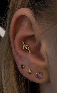 a close up of a person's ear with three different types of piercings