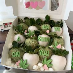 a box filled with white chocolate covered strawberries and topped with green leafy leaves