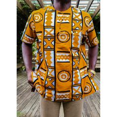 Our Adinkra African Print Short Sleeve Shirt Is An Essential Piece For Men. It Is Perfect For The Modern Man That Enjoys Elevating His African Wardrobe. This Very Stylish Piece Can Be Worn With Jeans Or Slacks To Bring Out The Look. Versatility Of The Design Goes With Any Style Of Wear. Description: Short Sleeve Shirt Hidden Front Pocket 100% African Wax Print Designed In The Usa, Imported From Ghana West African Dark Orange In Color Care Instruction: Dry Clean Only. Do Not Bleach. Iron Inside O Traditional Printed Yellow Tops, Traditional Short Sleeve Shirt With Graphic Print, Traditional Orange Cotton Tops, Mens African Wear Designs, African Print Shirts For Men, Men Senator Styles, African Wear Designs, Men African Wear, African Wear For Men