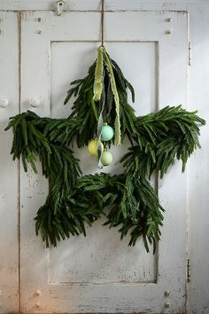 a wreath hanging on the side of a door with eggs and pine cones attached to it