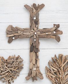 the cross is made out of driftwood and has two heart shaped decorations on it