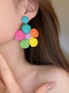 a close up of a person wearing colorful earrings