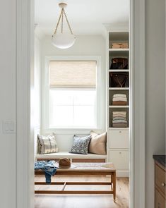 an open door leading to a living room with white walls and wood flooring on the other side