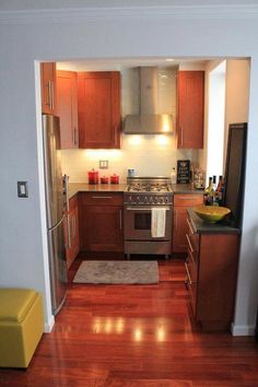 a kitchen with wood flooring and stainless steel appliances in the middle of the room