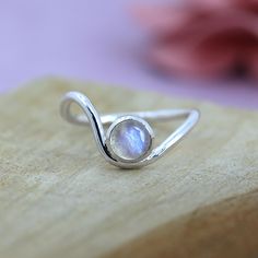 TITLE: -  Wave Ring Rainbow Moonstone Ring For Girls 925 Sterling Silver Handmade Jewelry Round Gemstone Ring   SPECIFICATIONS: - ❖ Metal:  925 Solid sterling silver ❖ Gemstone:  Moonstone  ❖Gemstone Size : 6 mm ❖ Gemstone Shape:  Round ❖ Total Weight:  2.5 Gram ❖ Gemstone Setting: Bezel   Note: Our use of natural stones may result in slight variations in texture and color in the actual product you receive, but the quality and grade of the stone remain consistent. FEATURES: -  * elegant Moonstone Silver Wave Ring, a perfect blend of simplicity and sophistication. Crafted from high-quality sterling silver, this ring features a beautifully polished moonstone that radiates a soft, iridescent glow. Its unique wave design adds a touch of modern elegance, making it an ideal accessory for any occ Silver Ring Gemstone, Adjustable Sterling Silver Moonstone Birthstone Ring, Dainty Sterling Silver Moonstone Ring, Sterling Silver Moonstone Toe Ring For Anniversary, Sterling Silver Moonstone Ring With Birthstone, Gemstone Setting, Lover Jewelry, Ocean Jewelry, Wave Ring