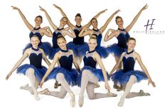 a group of young ballerinas posing for a photo in blue tutu skirts