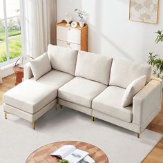 a living room with a sectional couch and coffee table in front of a large window