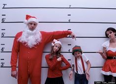 three people dressed up as santa clause standing in front of a muggy man and woman