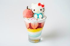 a hello kitty ice cream sundae with an apple and strawberry on the top in a glass