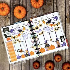 an open planner book with pumpkins around it on a wooden table next to small pumpkins