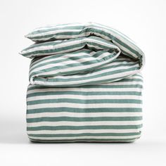 a green and white striped comforter set on top of a bed with two pillows