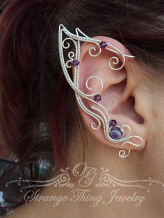 a woman wearing an ear cuff with purple stones