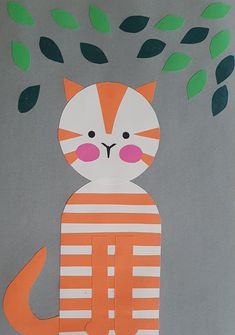 an orange and white cat with green leaves on it's head sitting under a tree