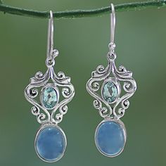 India's Neeru Goel presents a new awe-inspiring pair of earrings. Whimsical sterling silver tendrils surround a sparkling blue topaz gemstone at the peak of each dangle earring. Below, a blue oval cabochon chalcedony stone is suspended from the high-polish sterling silver frame, making the calm blue tones the center of attention. Chalcedony Stone, Blue Topaz Gemstone, Handmade Wire Jewelry, Topaz Earrings, Blue Chalcedony, Lovely Earrings, Topaz Gemstone, Hook Earrings, Jewelry Gift Box